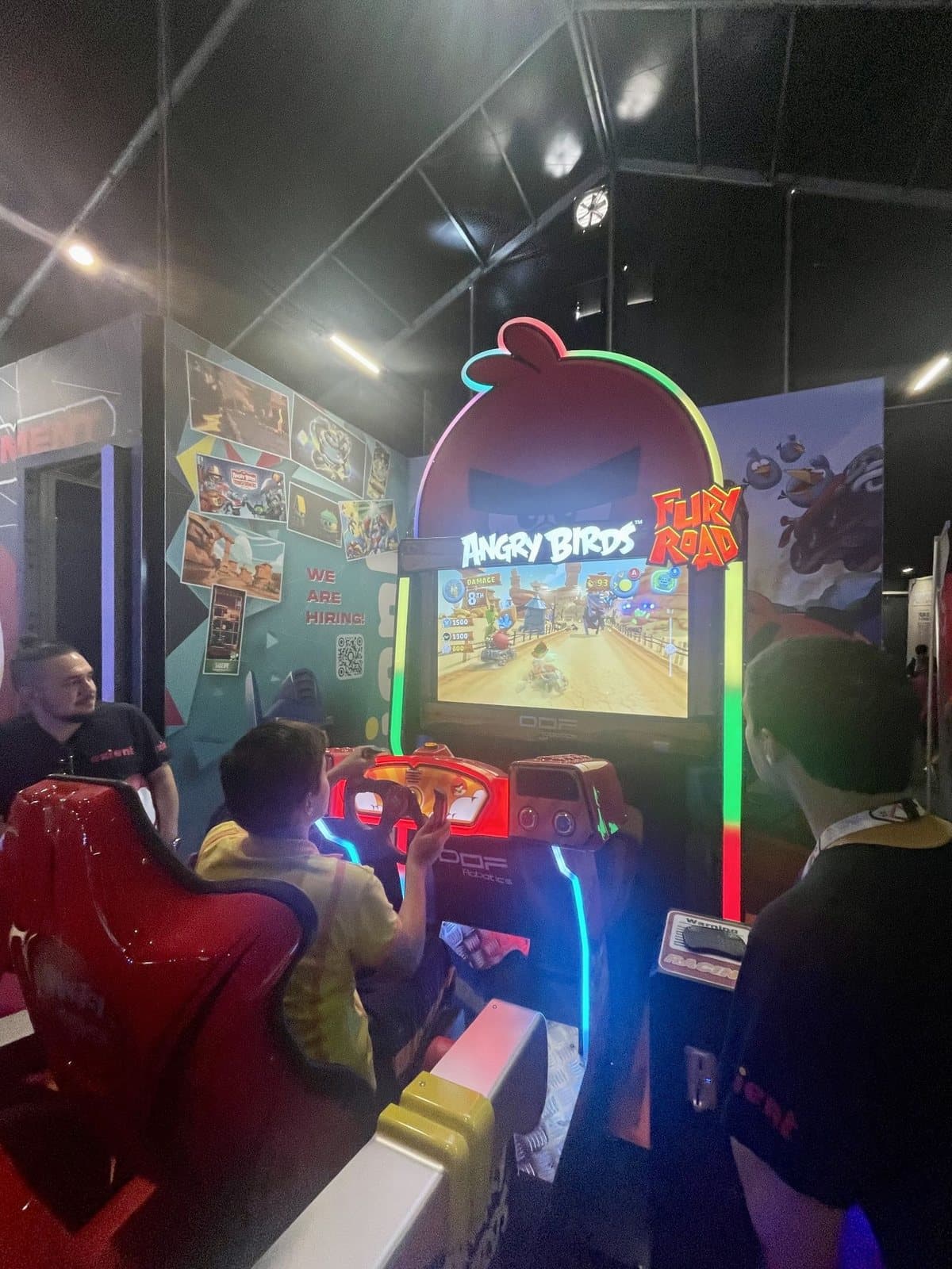 A player racing in the Angry Birds Fury Road motion cabinet at a public event, with the Rocky Canyons track on the cabinet screen.