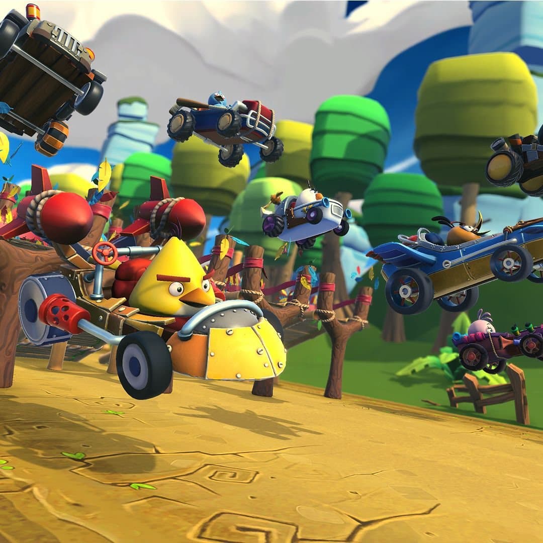 Chuck leading a pack of six karts through the Feathered Woodlands, with rivals launching off the track around him.